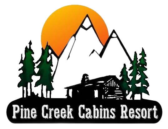 Logo for Pine Creek Cabins Resort featuring a log cabin, evergreen trees, and snow-capped mountains against an orange sun.