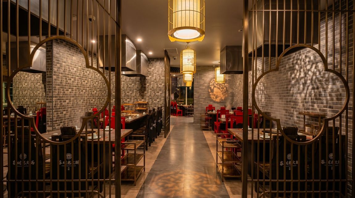 Elegant restaurant interior with red seating, hanging lanterns, and ornate circular metal decor