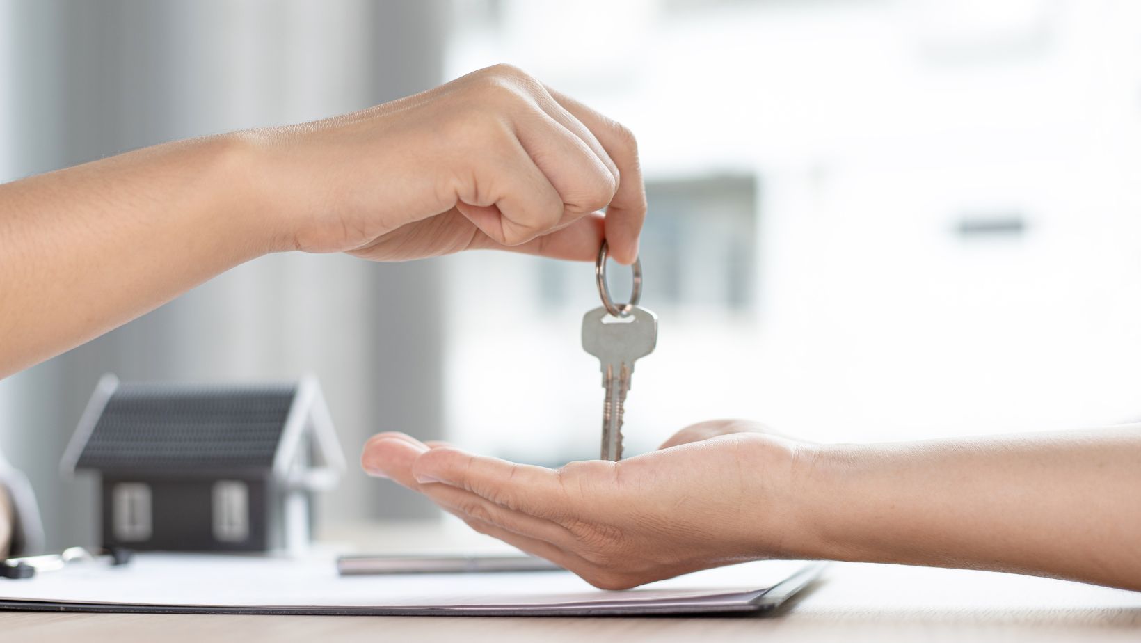 Person holding keys to new apartment building investment property