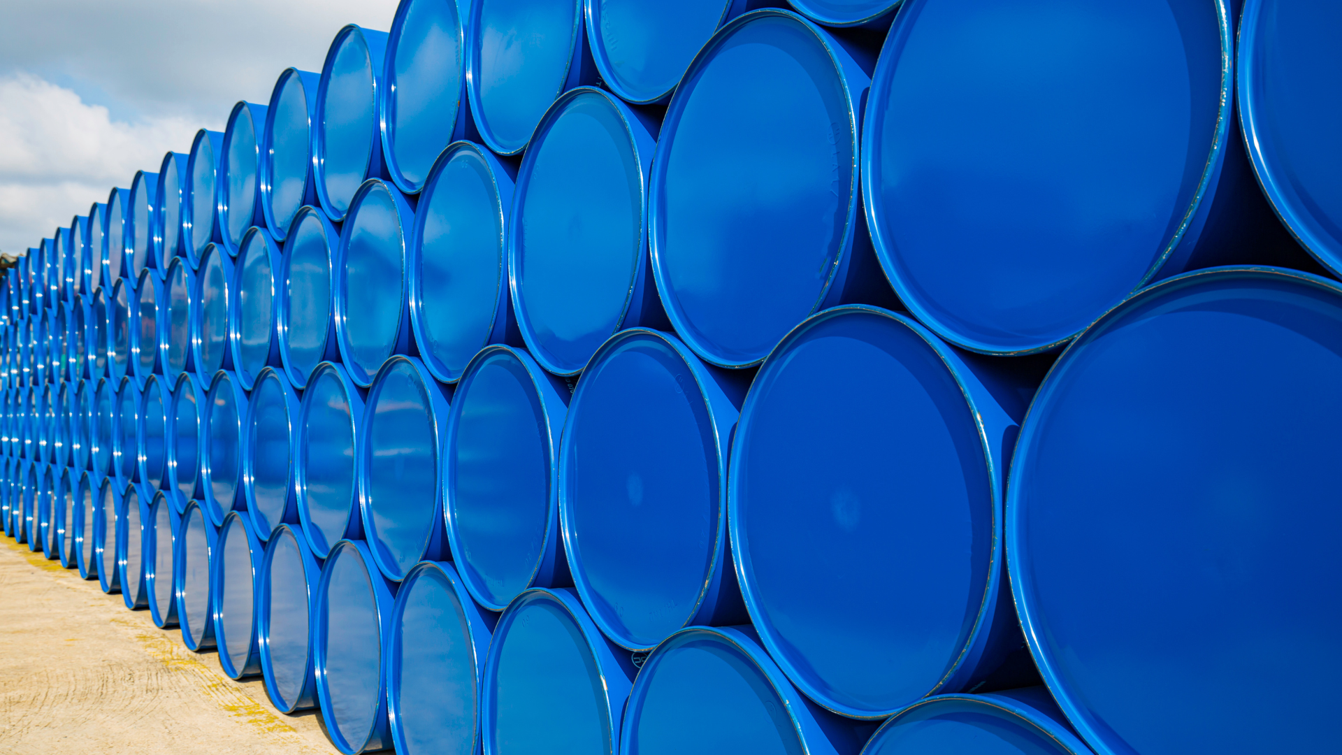 Blue barrels stacked in rows, outdoors.