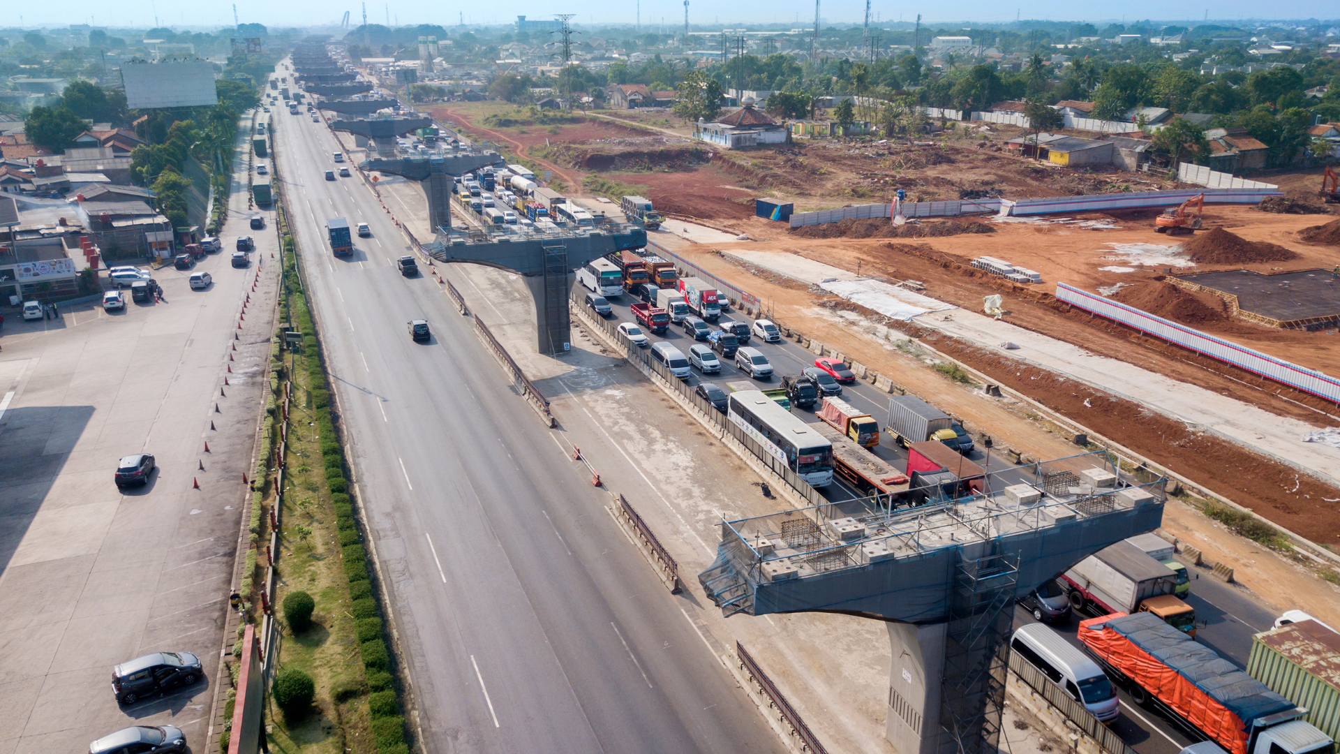 Highway under construction; traffic jam on a busy road with elevated structures in progress.
