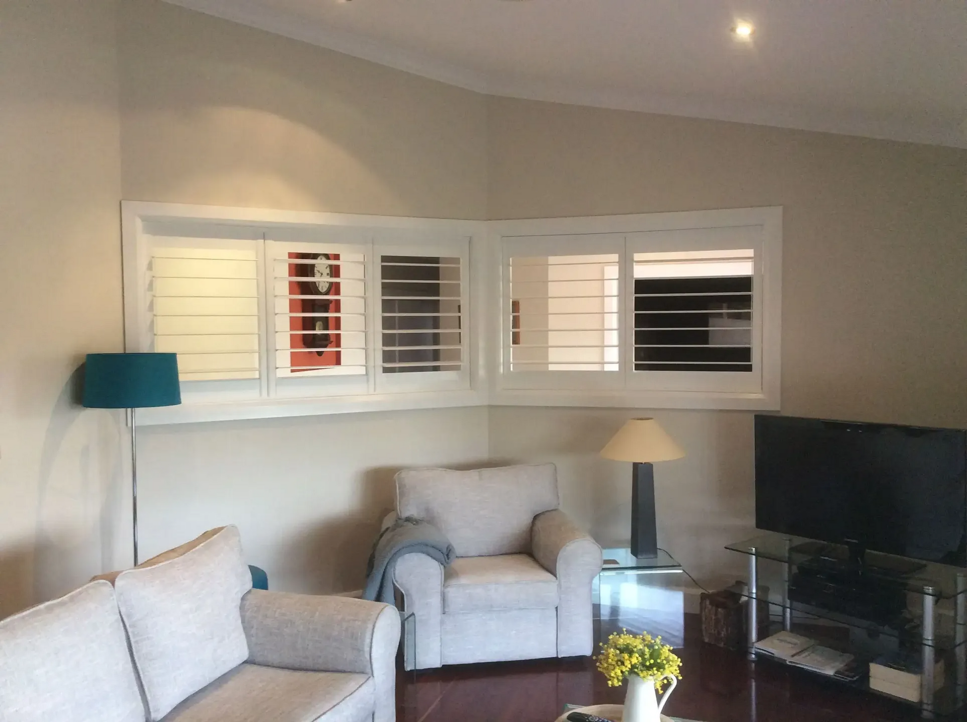 A Living Room With a Couch, Chair, Lamp and Television — Port Blinds & Awnings In Nambucca Heads, NSW