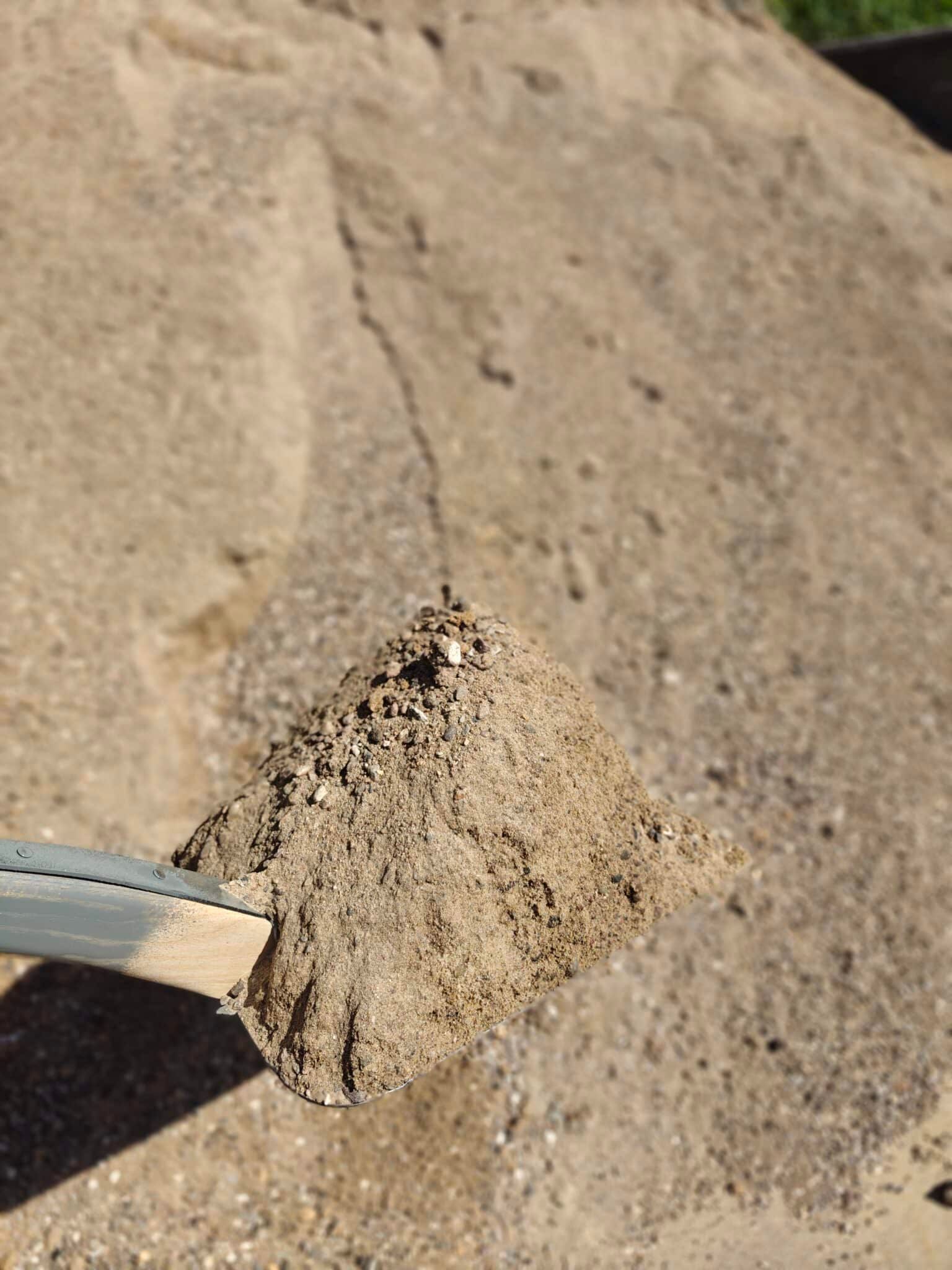 Lille gråbrun bunke af jord eller sand på en betonoverflade med et kabel, der kommer ind fra venstre.