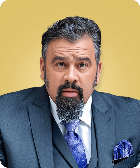 Portrait of a man in a dark suit and blue tie against a yellow background, looking serious.