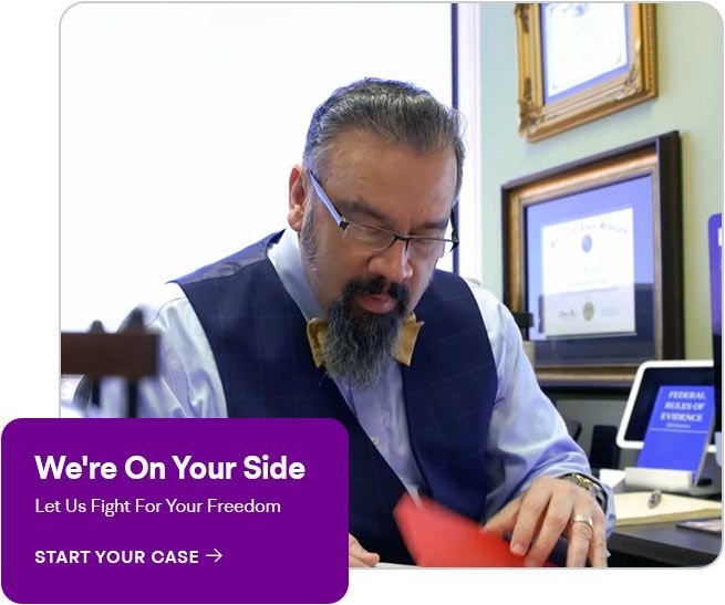 Attorney reviewing paperwork at a desk with a “We’re On Your Side” legal aid banner.