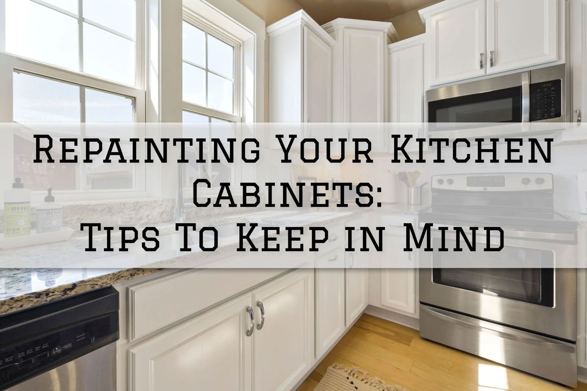 White kitchen cabinets with stainless steel appliances. Text: Repainting Your Kitchen Cabinets: Tips To Keep In Mind.