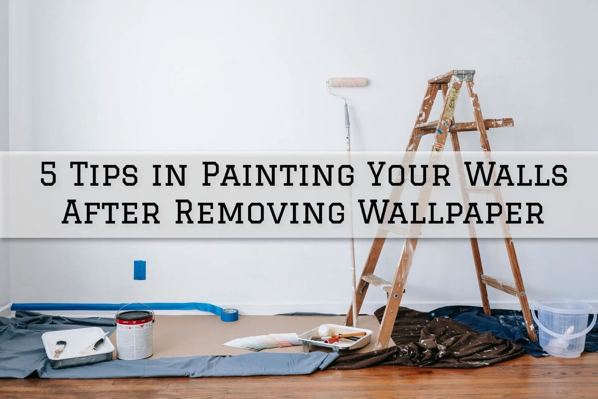 Room with paint supplies, ladder, and a wall. Text reads