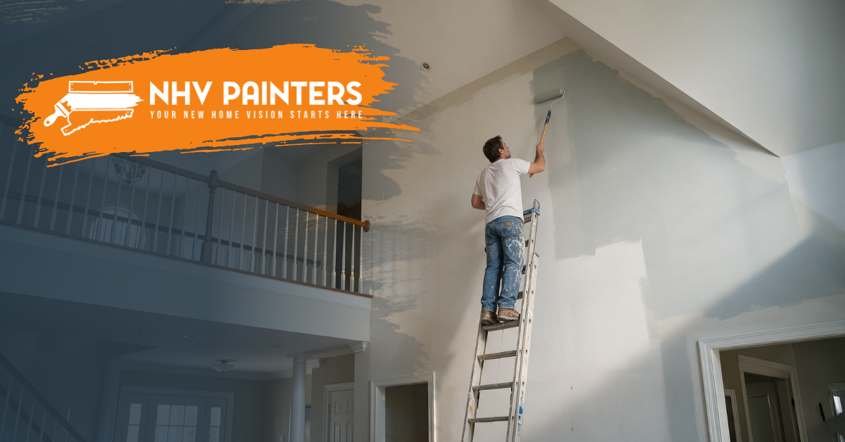Painter on a ladder painting a high interior wall in a bright home, with an NHV Painters logo overlay