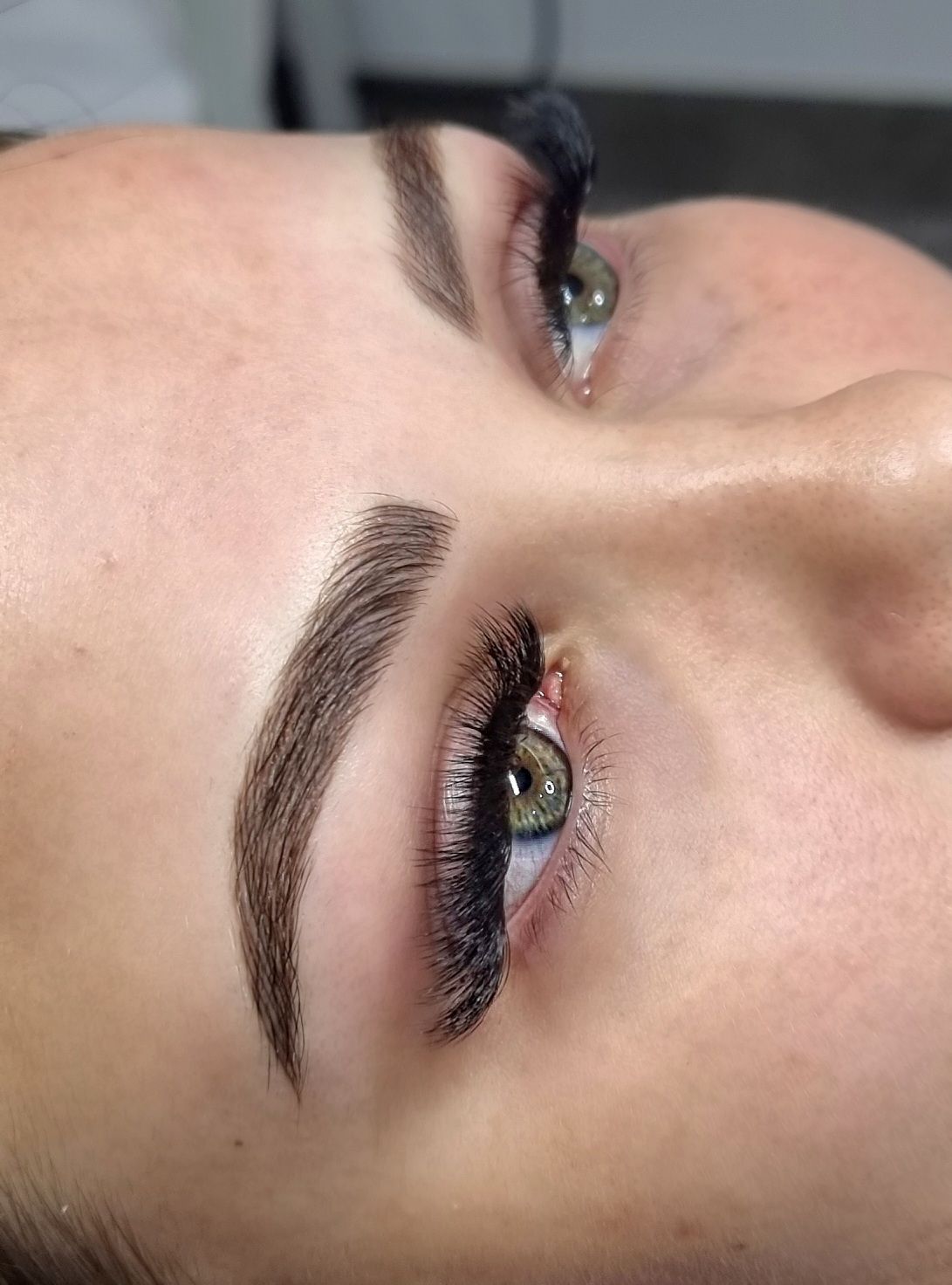 Close-up of a face showing shaped eyebrows and gold eye makeup in soft light — On Point Cosmetic Tattoo Studio In Noosa, QLD