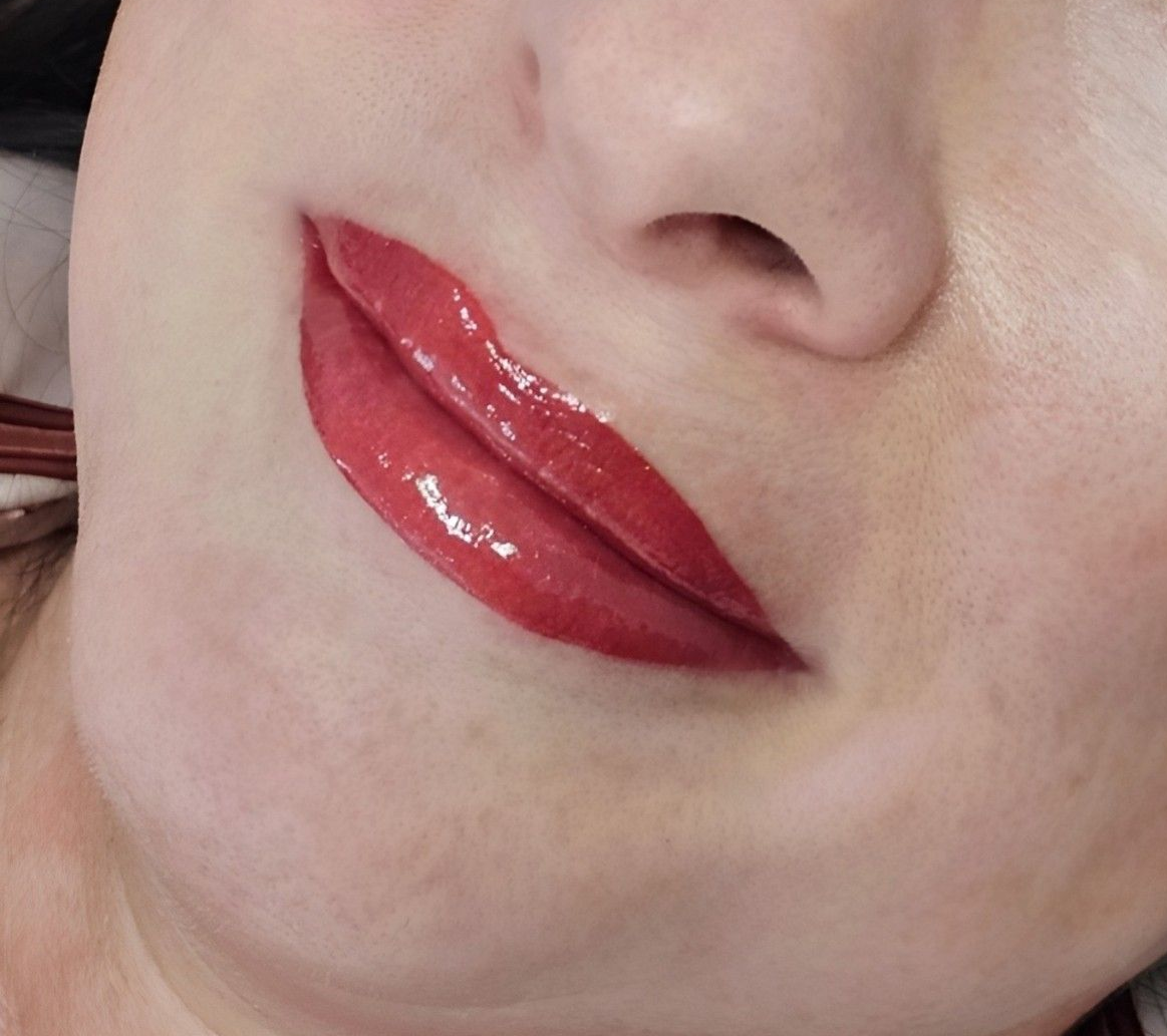 Close-up portrait of a smiling woman with glossy red lipstick and shimmery eye makeup — On Point Cosmetic Tattoo Studio In Noosa, QLD