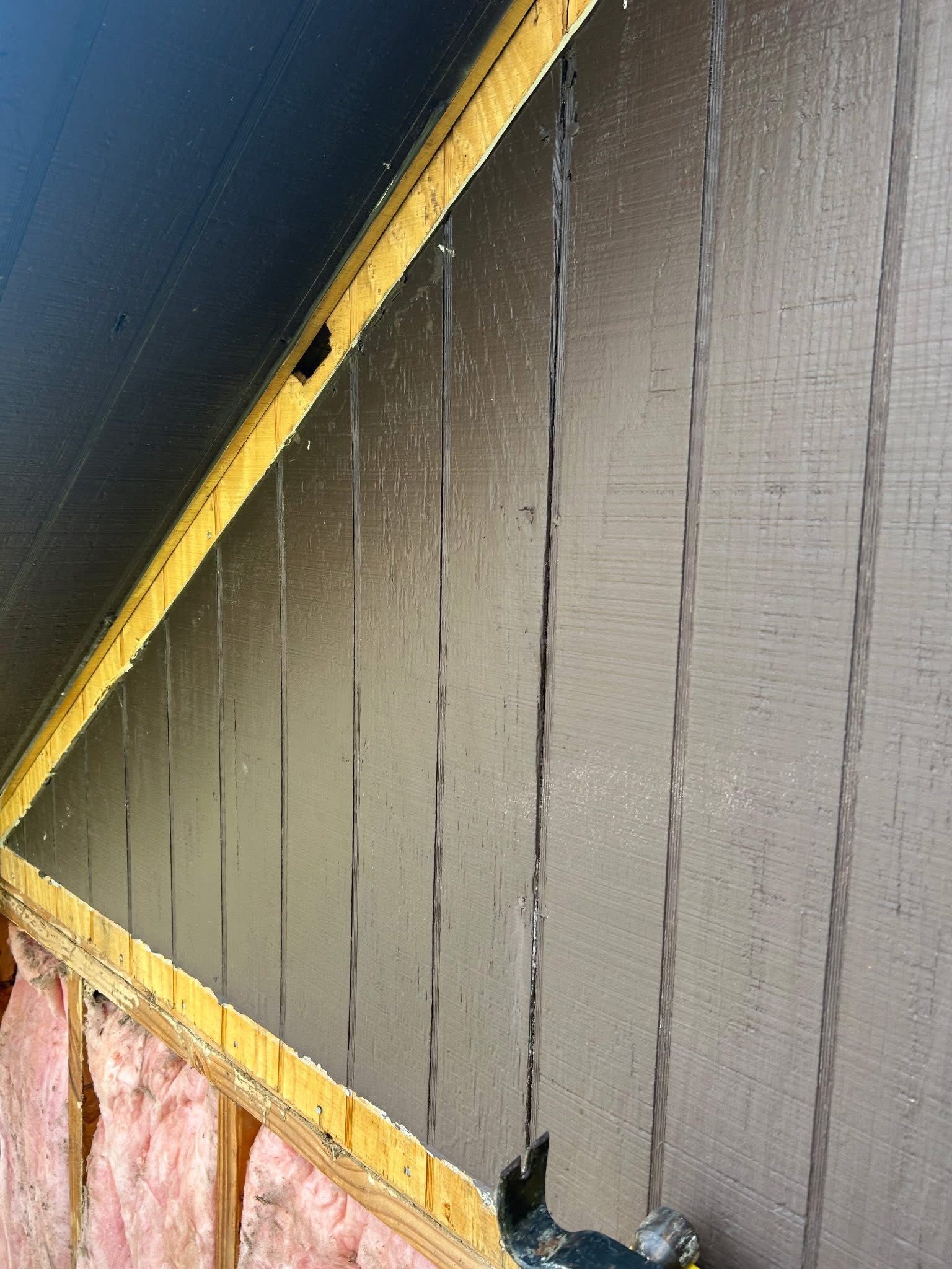 A close up of a wall with insulation and a roof.