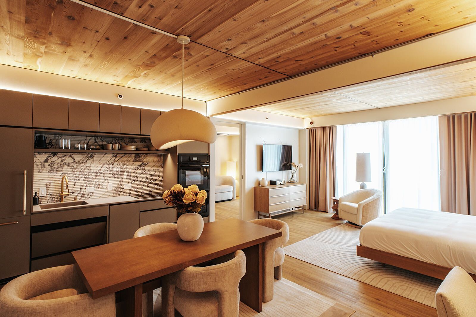 Cozy bedroom with wooden shelves, a bed, desk, and warm lighting in a modern rustic interior