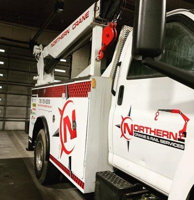 White Northern Crane truck with red logo, parked in a bay, ready for crane or rail service.