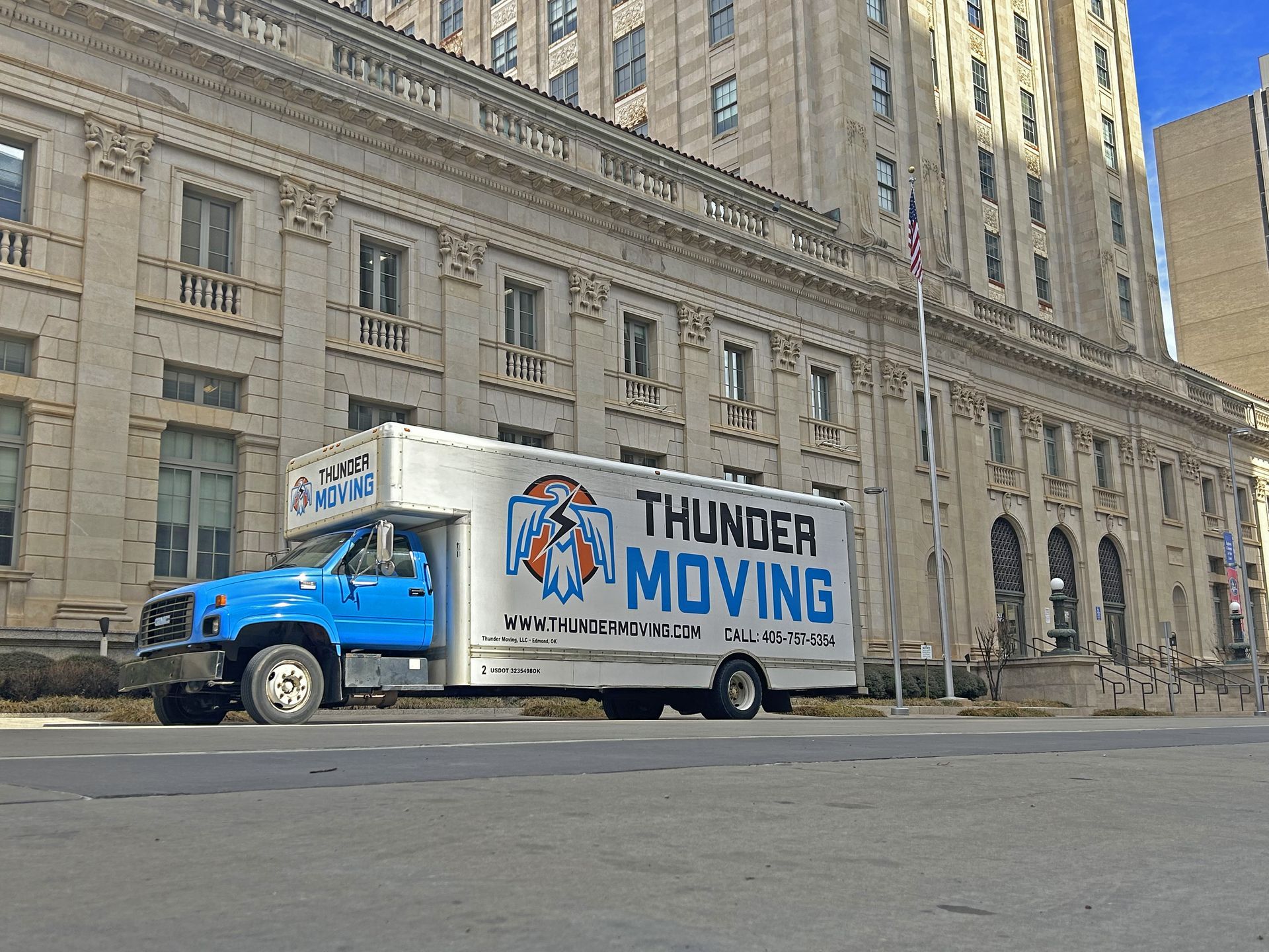 Thunder moving box truck parked near large building