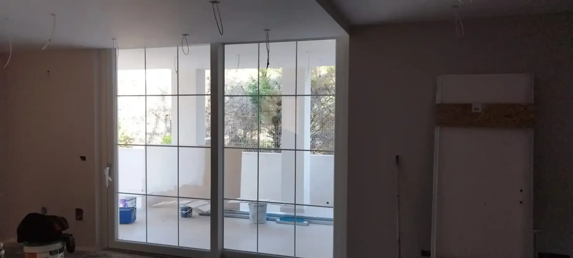 Vista interna con ampia finestra e stanza parzialmente rifinita.