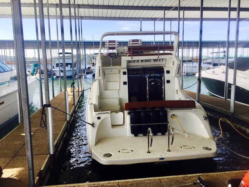 A boat is docked in a covered dock and has the word brake on the back