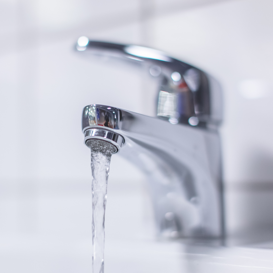 Un primer plano de un grifo del que sale agua.