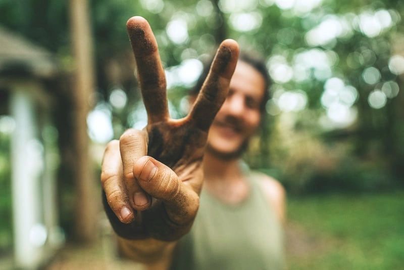 A man is making a peace sign with his hands.