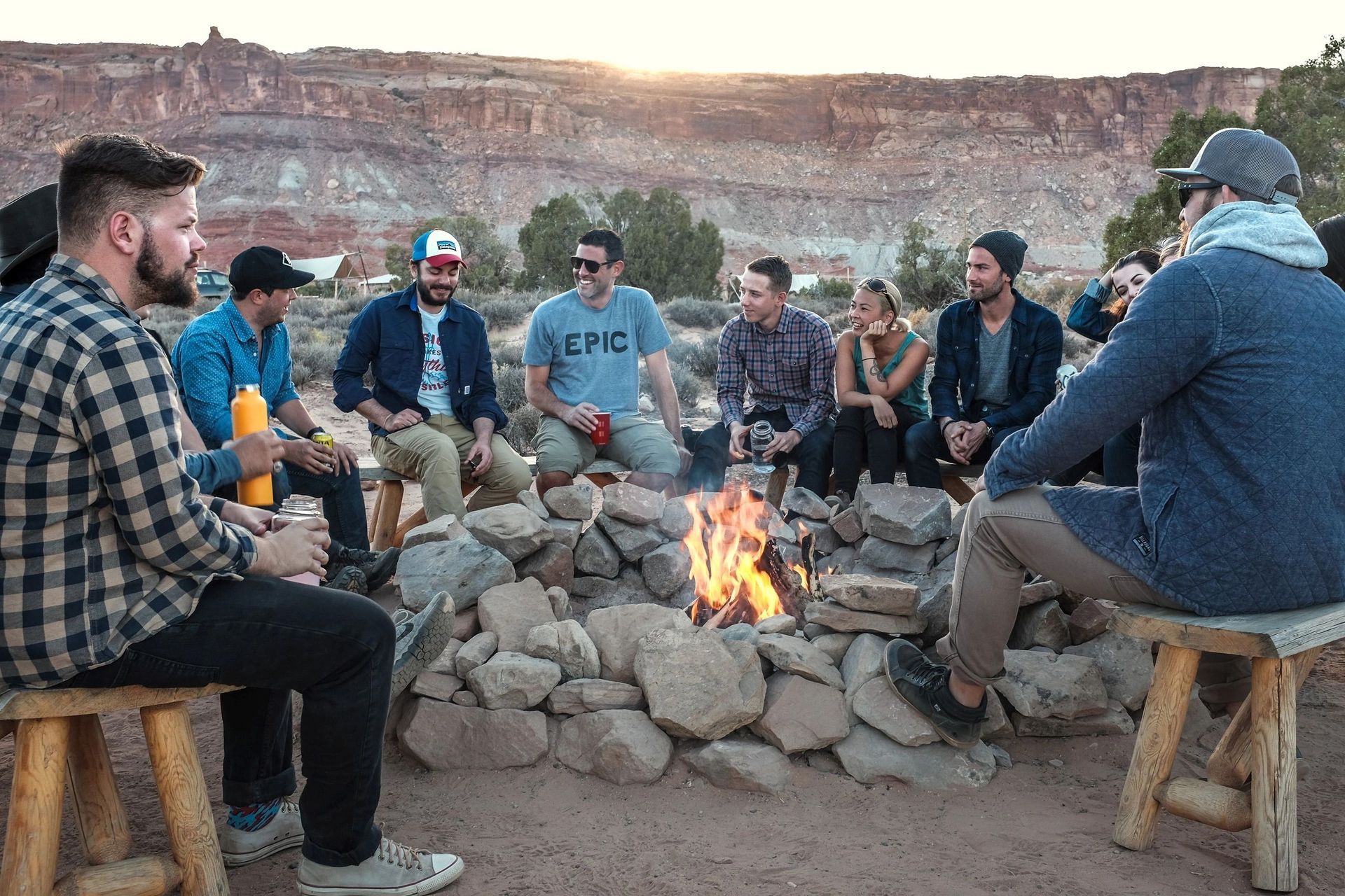 A group of people are sitting around a fire pit.
