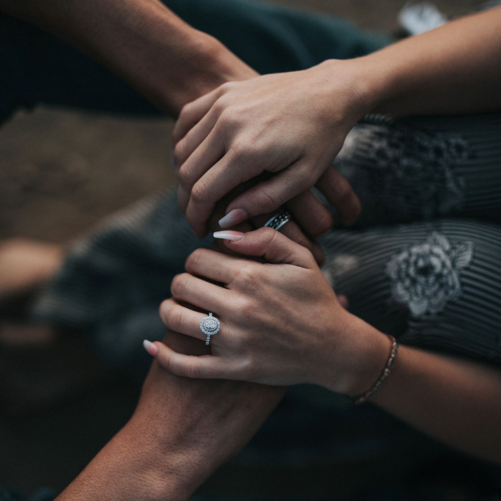 A woman with a ring on her finger is holding another woman 's hand