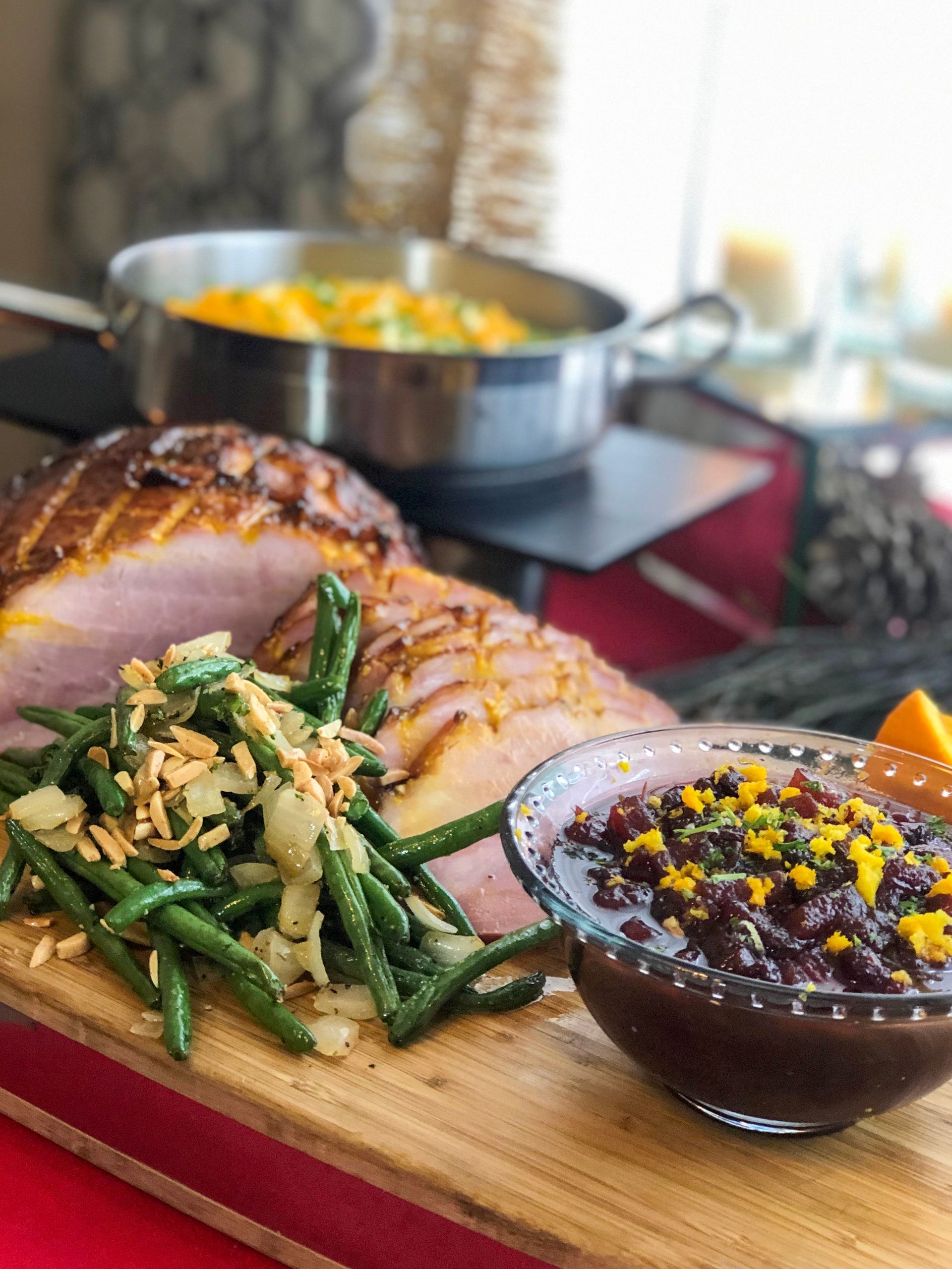 Ham, green beans, and cranberry sauce on a wood board.