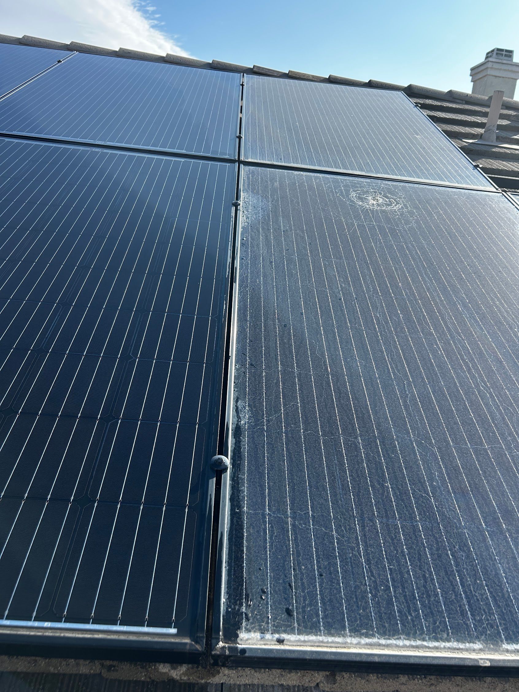 Close-up of two blue solar panel arrays on a rooftop under a clear sky