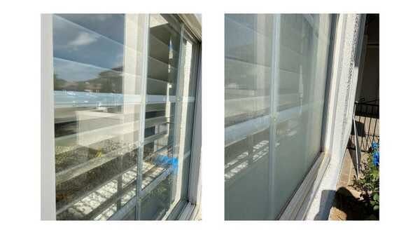 Split view of window glass with visible streaks and reflections, showing a cleaner left pane and dirtier right pane