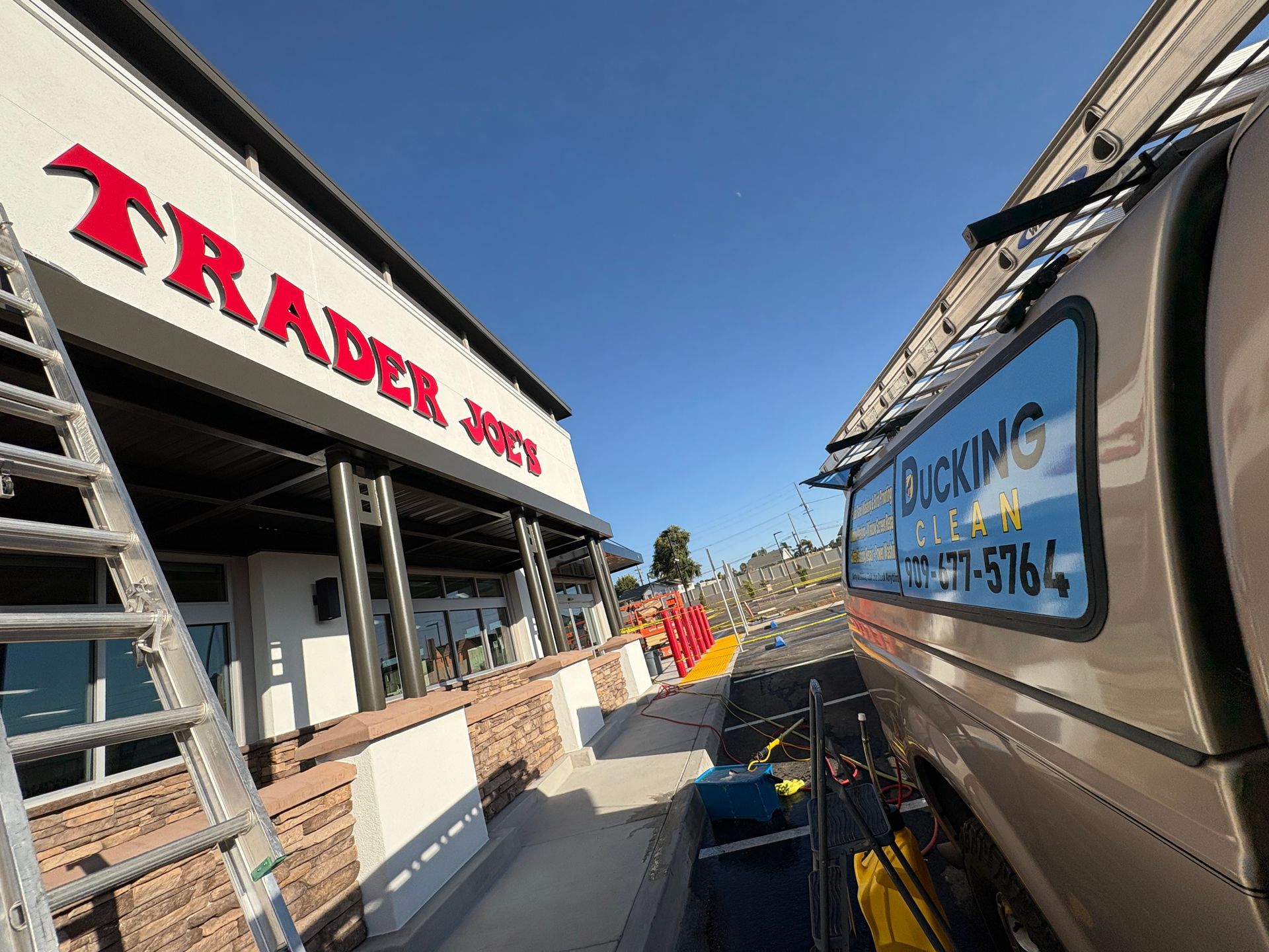 Trader Joe’s storefront beside a parked utility truck on a sunny street at the Yucaipa location
