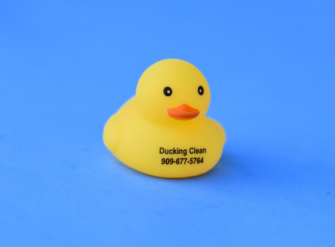 Yellow rubber duck with black eyes and orange beak on a blue background, with Duckling Clean text on its chest
