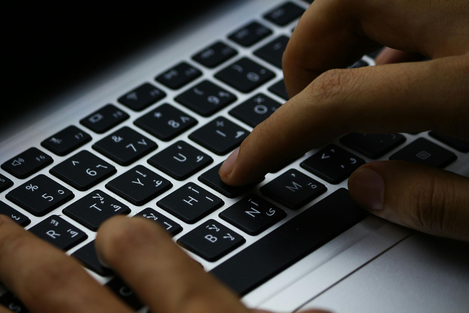 A close up of a person typing on a laptop keyboard
