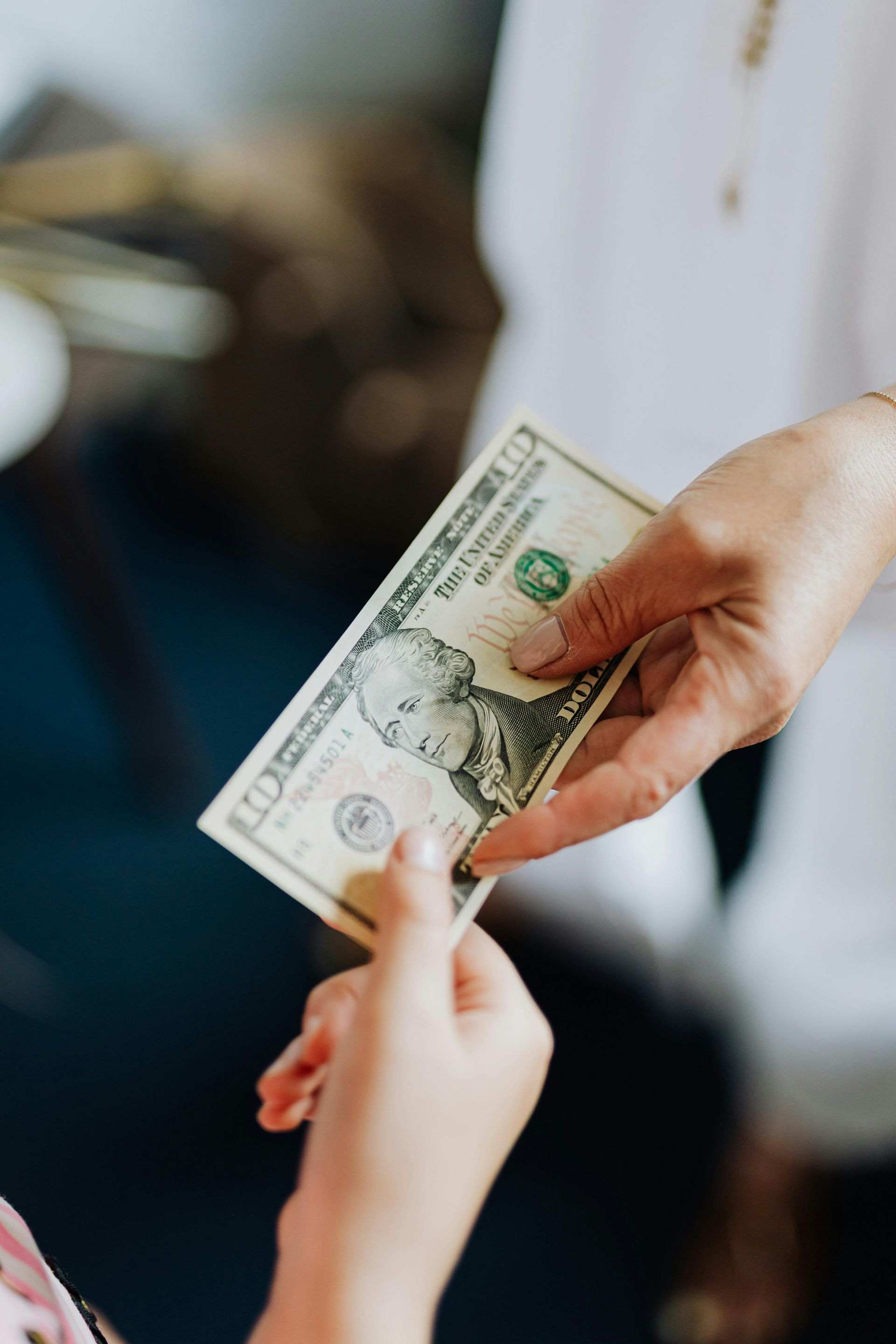 A woman is giving a child a dollar bill.