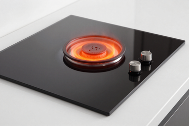 Ceramic glass cooktop with a glowing burner on a clean countertop