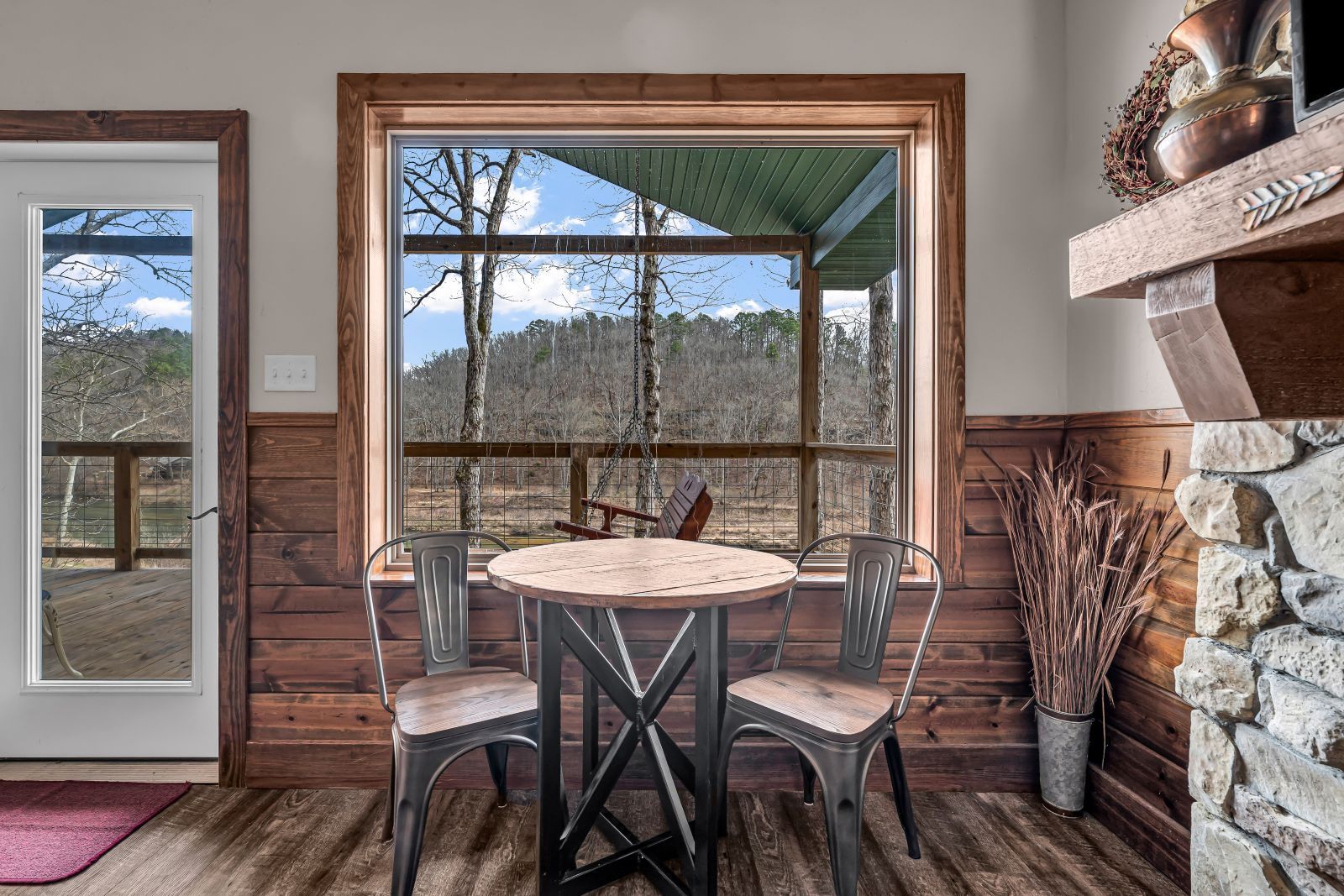 Cozy dining nook with round table, two chairs, and large windows overlooking snowy mountains
