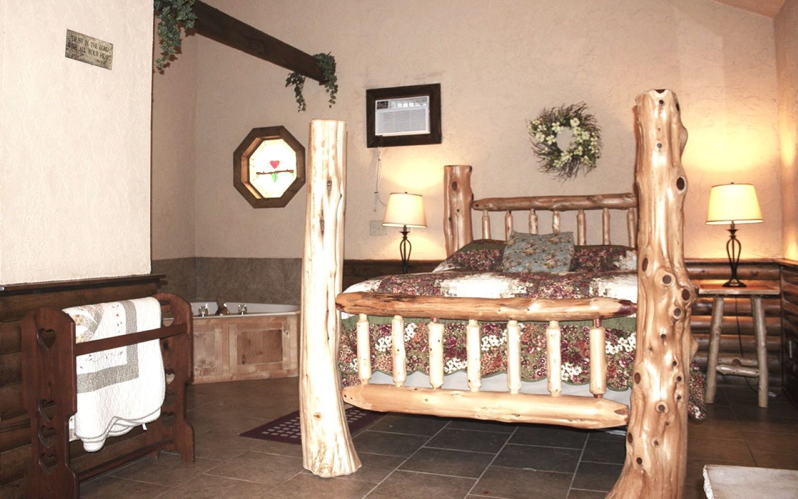 Rustic bedroom with log bed frame, bedside lamps, floral bedding, and wall decor