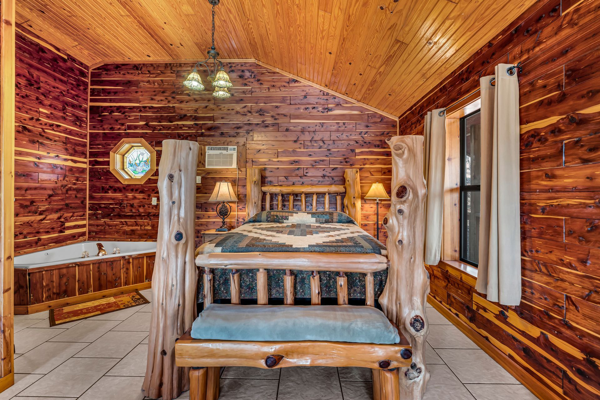 Rustic log cabin dining room with a wooden table, benches, and warm amber lighting