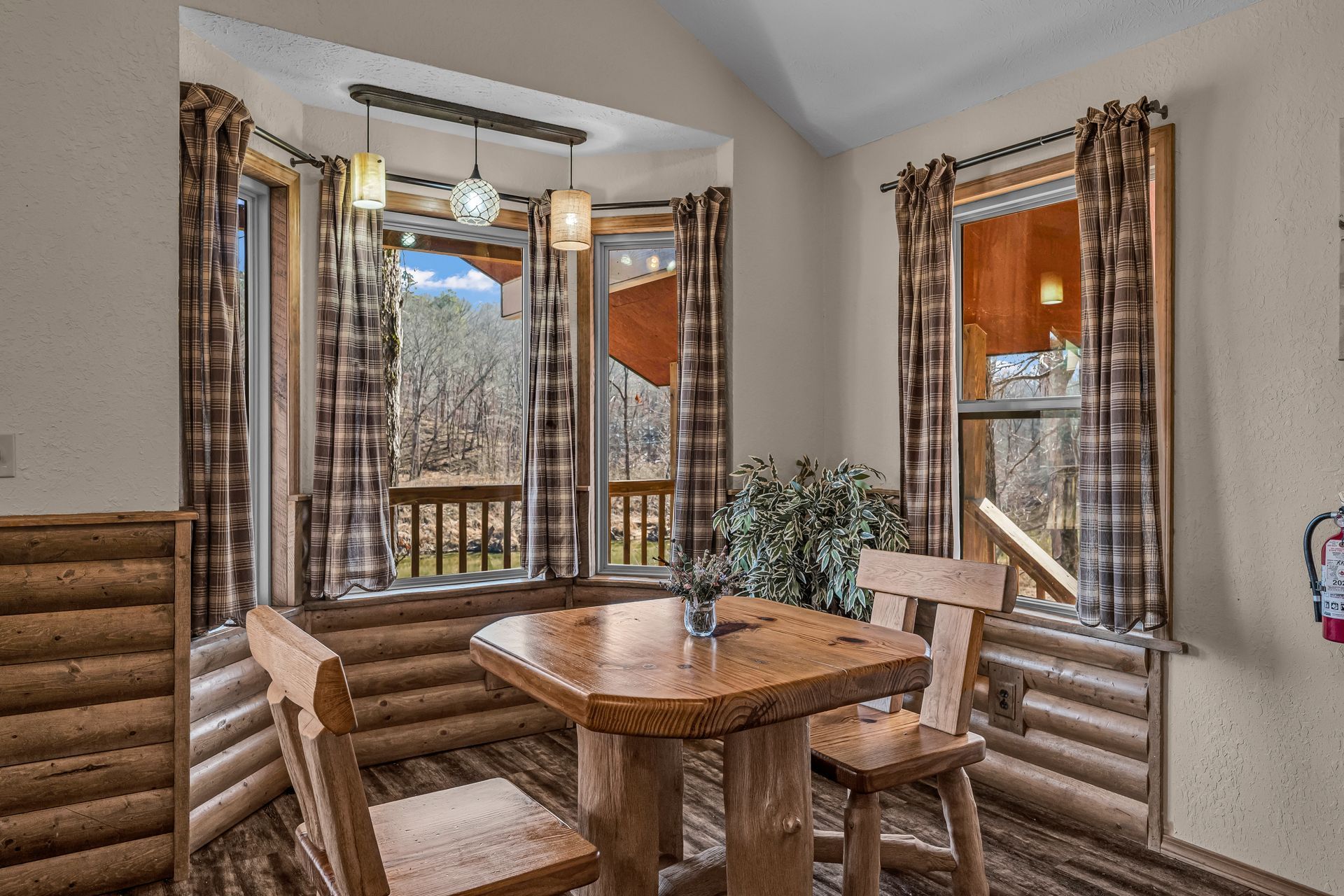 Cozy dining nook with wooden table and benches by windows, overlooking a snowy outdoor view