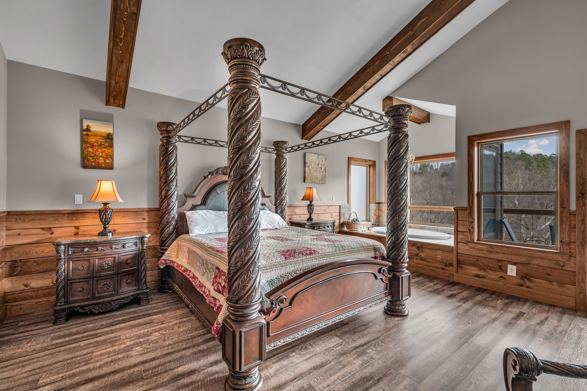 Rustic bedroom with carved wooden canopy bed, wood-paneled walls, and large windows