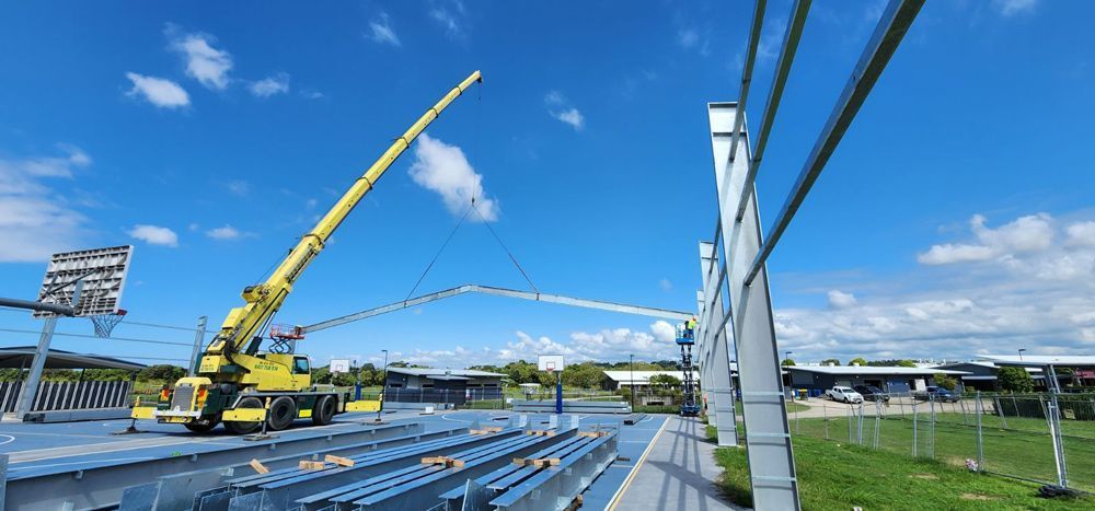 A Yellow Crane Lifting a Cable or Structure Under a Blue Sky — Statewide Lift & Shift Pty Ltd In Paget, QLD