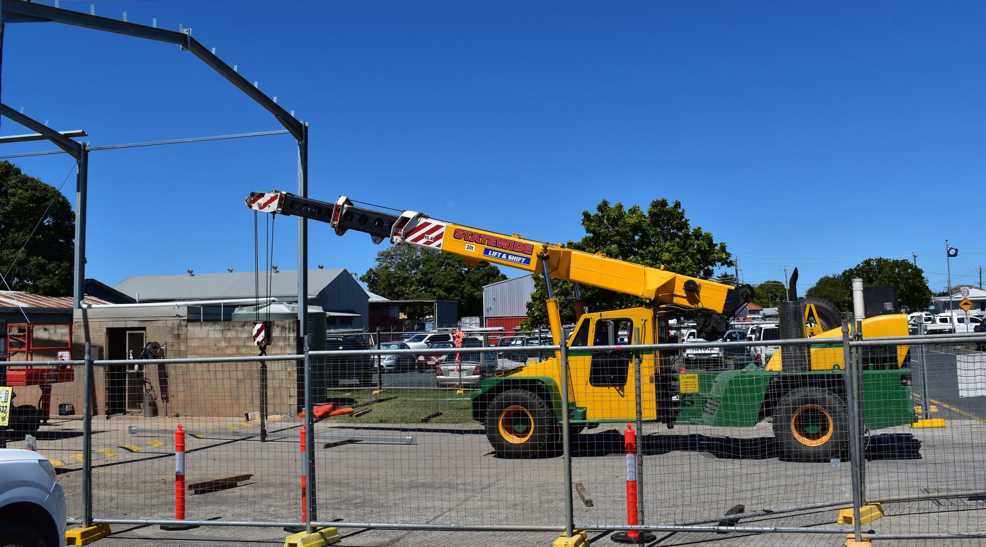 Yellow Crane Lifting in a Construction Zone, Sunny Day — Statewide Lift & Shift Pty Ltd In Paget, QLD