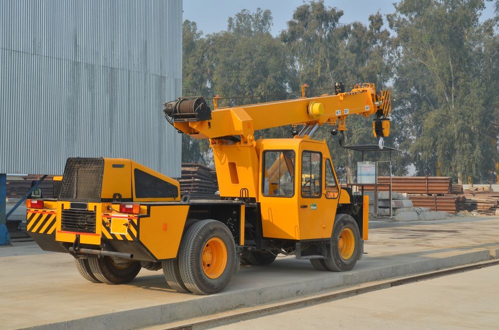 Yellow Industrial Crane on Wheels in an Outdoor Industrial Setting — Statewide Lift & Shift Pty Ltd In Bowen, QLD