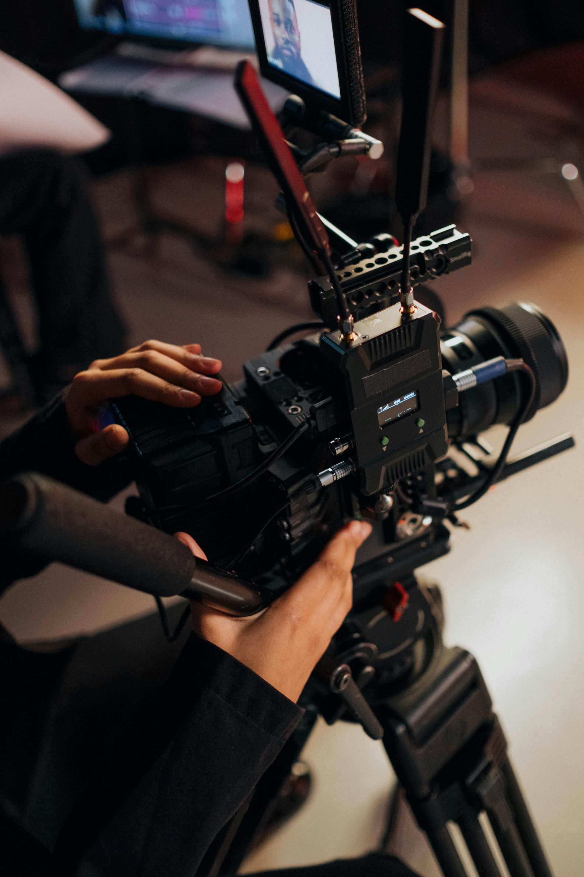 A person is holding a video camera on a tripod.
