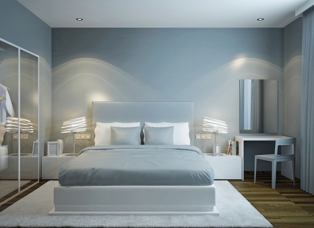 Bedroom With Bed, Vanity, and Mirrored Light Blue Wall, and Wooden Floors — White Rose Electrical in Coffs Harbour, NSW