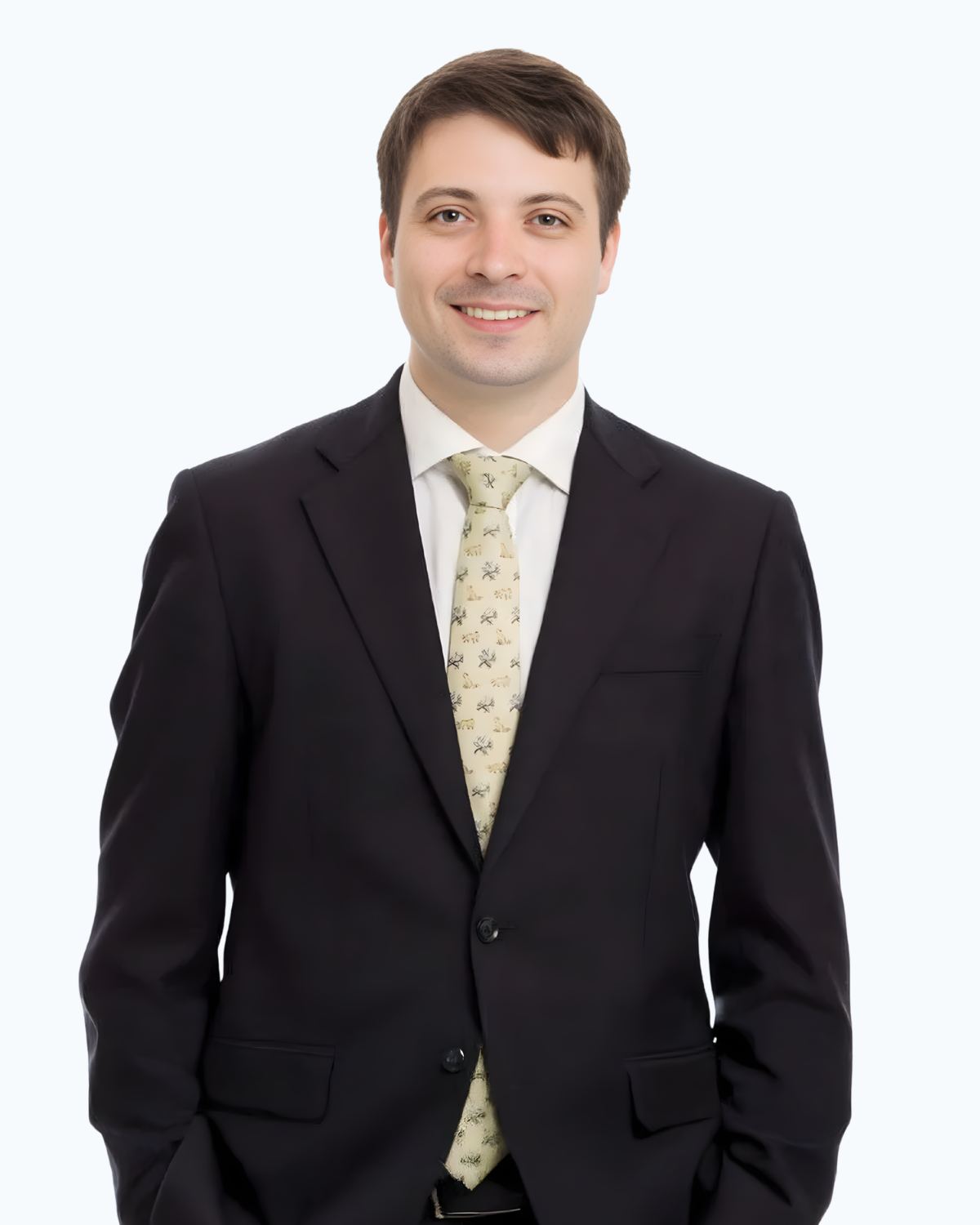 A man in a suit and tie is standing with his hands in his pockets.
