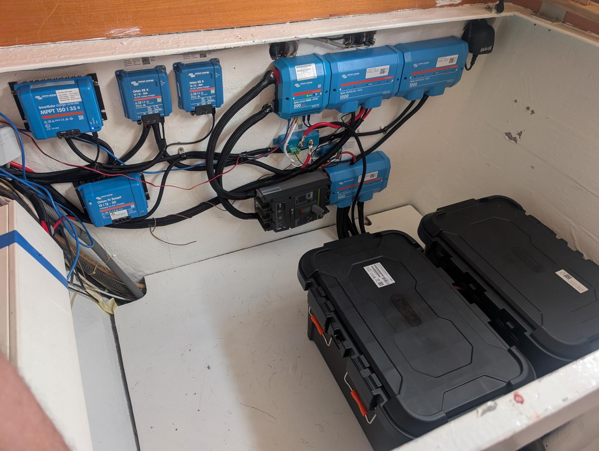 Electrical Cabinet With Blue Control Modules, Wiring, And Two Black Hard Cases Inside An Open Enclosure — Symbiote Systems in Airlie Beach, QLD