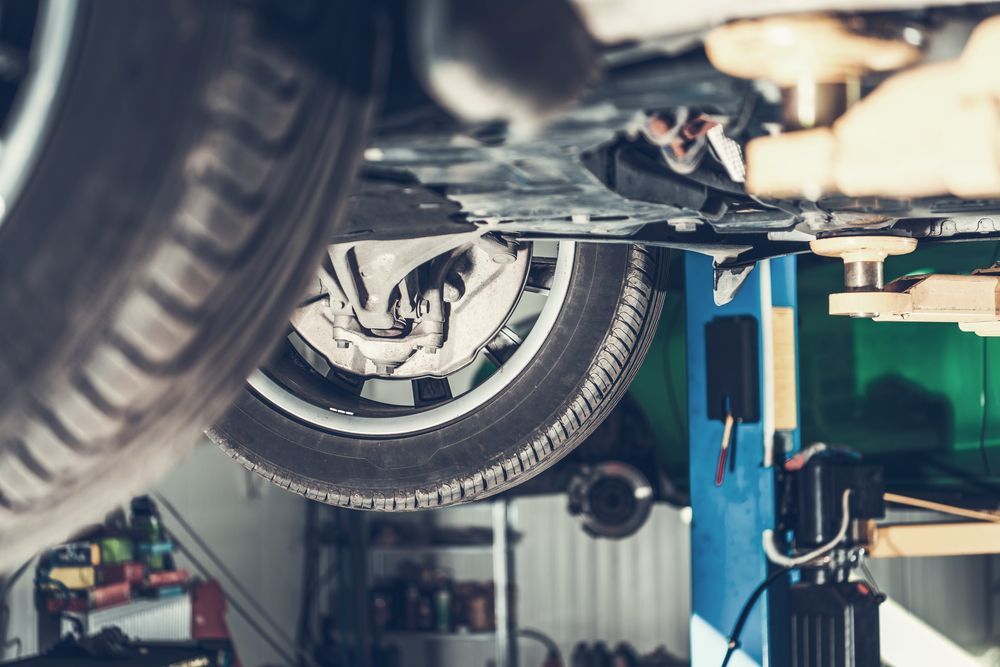 Car on a Lift in a Garage, View From Below Showing Tire — Symbiote Systems in Airlie Beach, QLD