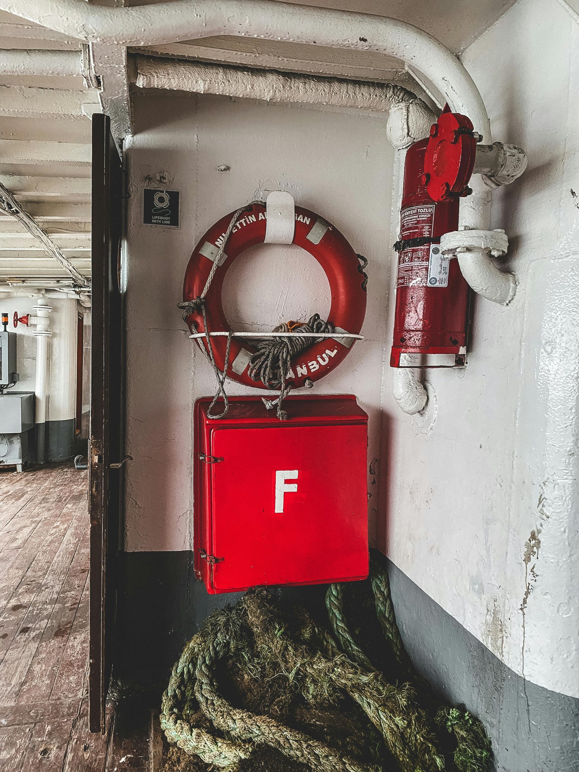 Red Fire Alarm Box Mounted on a Gray Marble Wall in a Hallway — Symbiote Systems in Airlie Beach, QLD