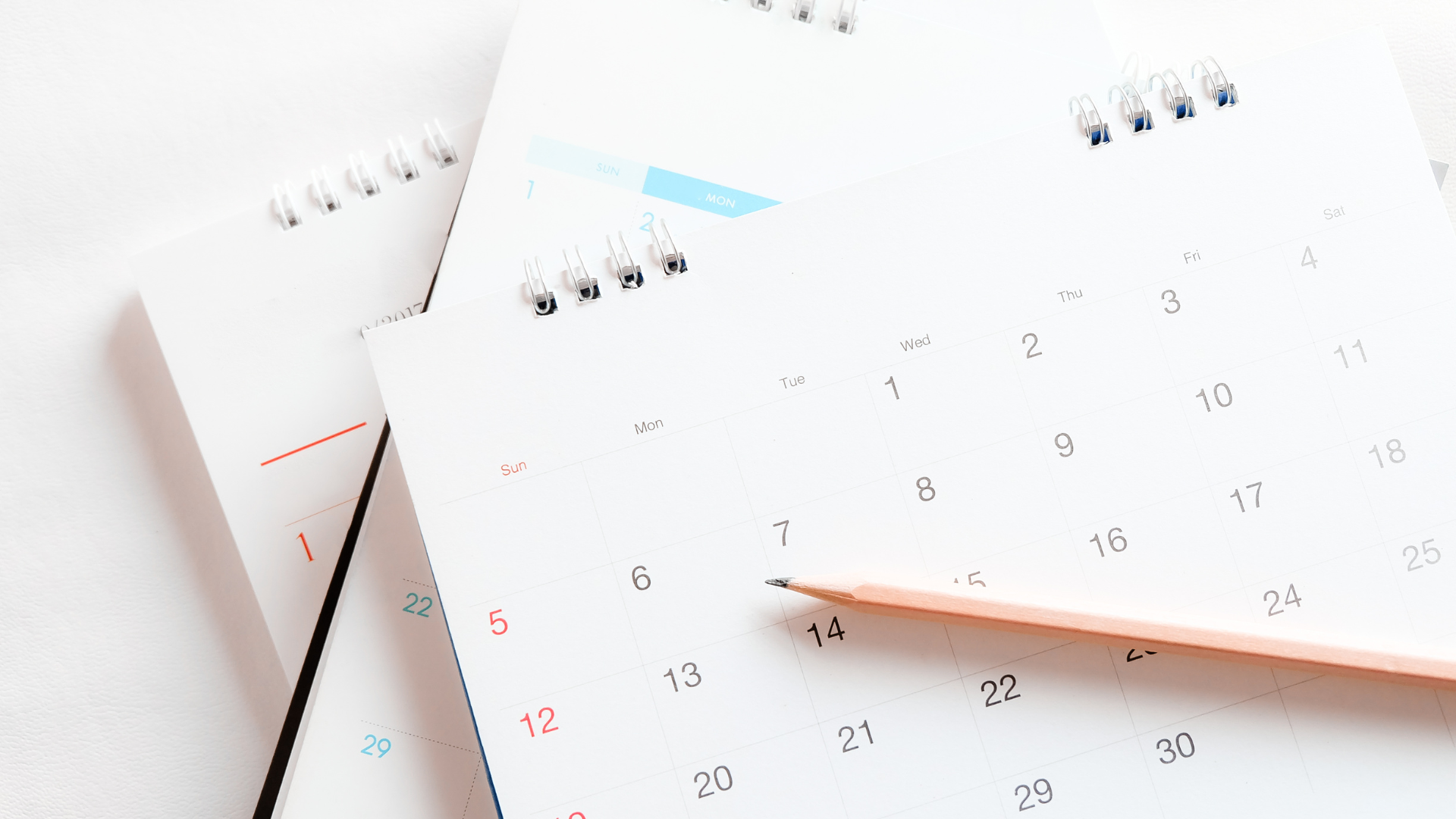 A calendar with a pencil on top of it.