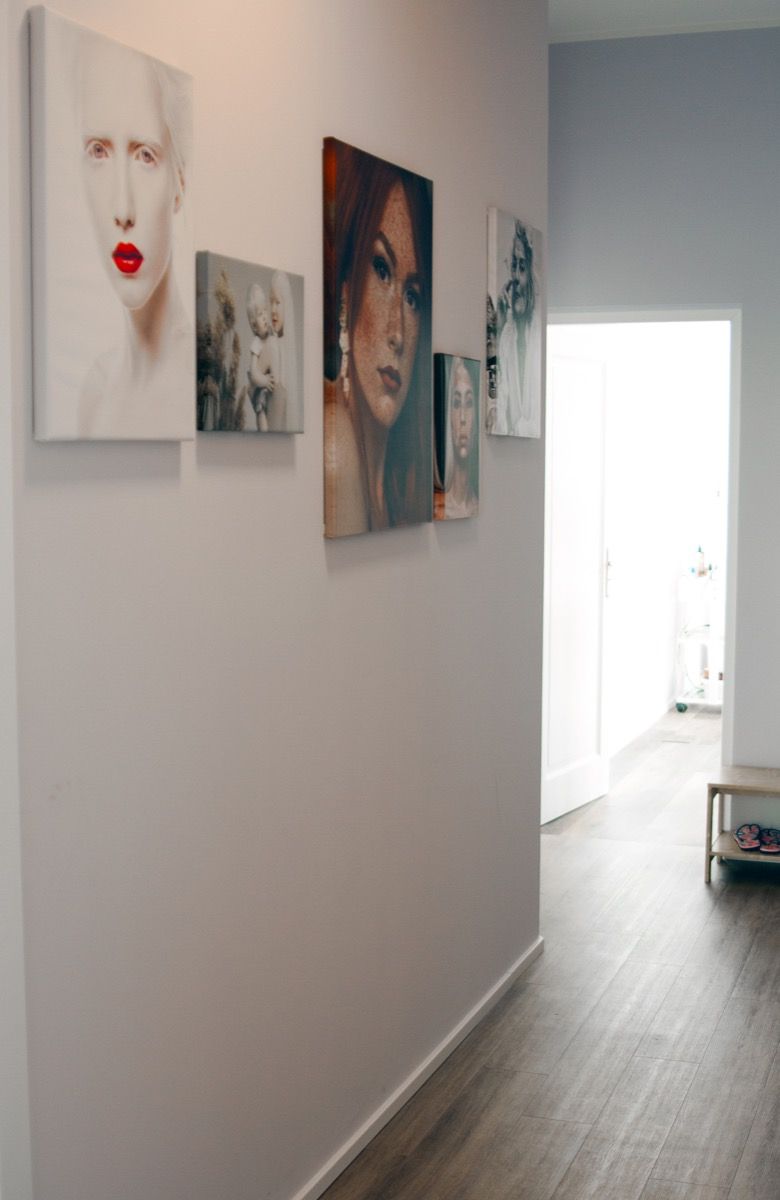 Ein Flur mit Gemälden eines Frauengesichts an der Wand