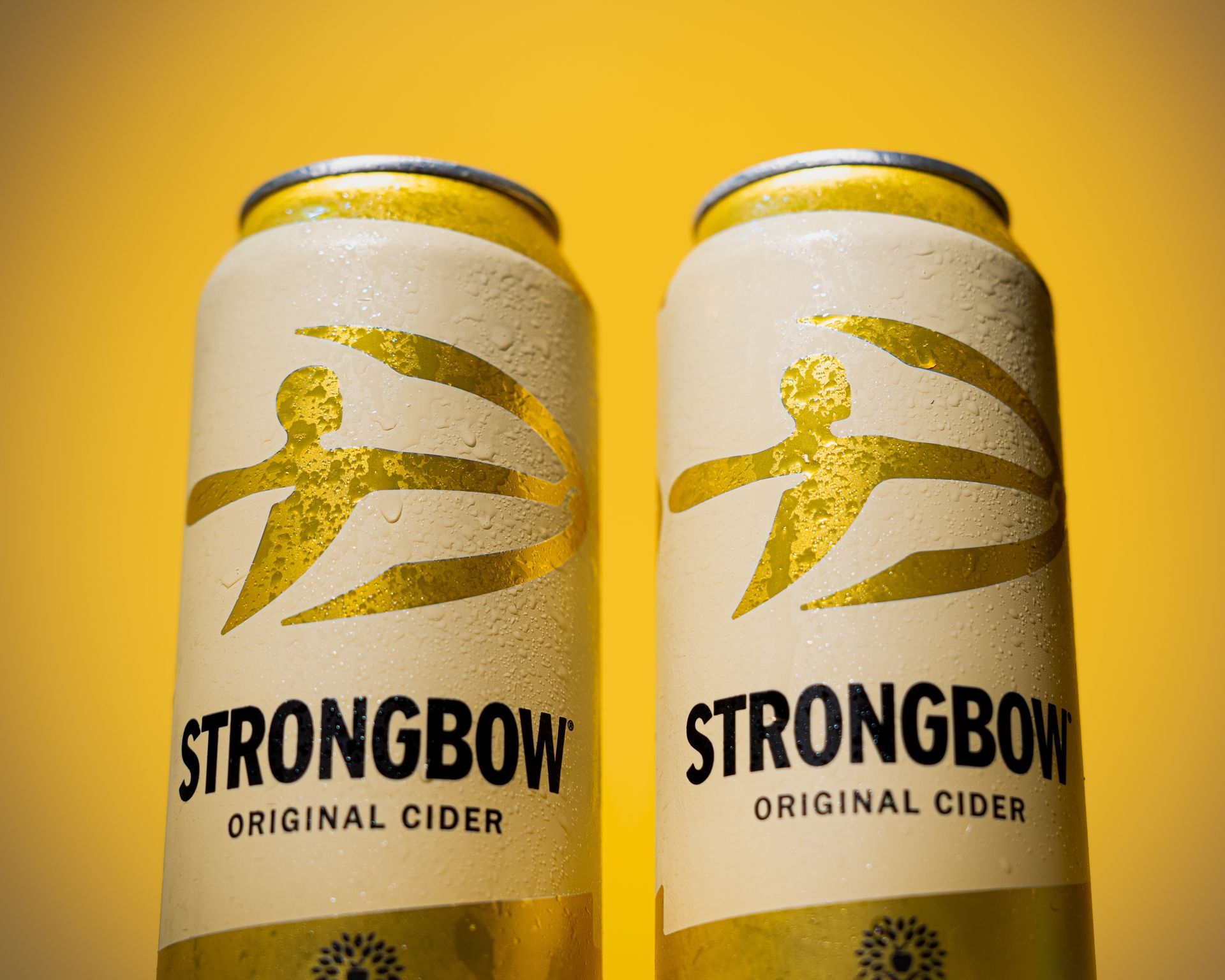 Two cans of strongbow original cider on a yellow background product photography in Warwickshire 
