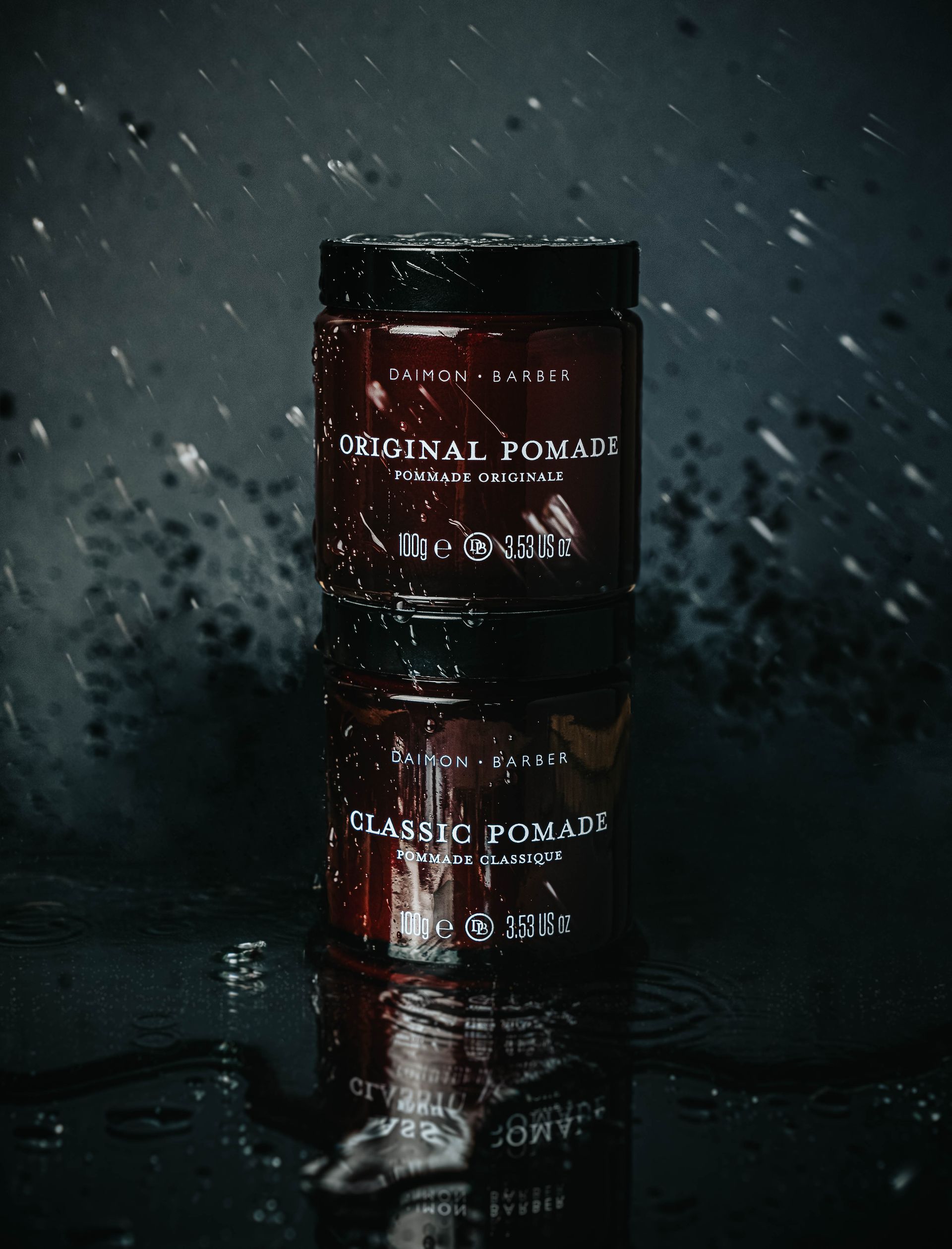 A jar of pomade is sitting on a table in the rain. product photography in Warwickshire 